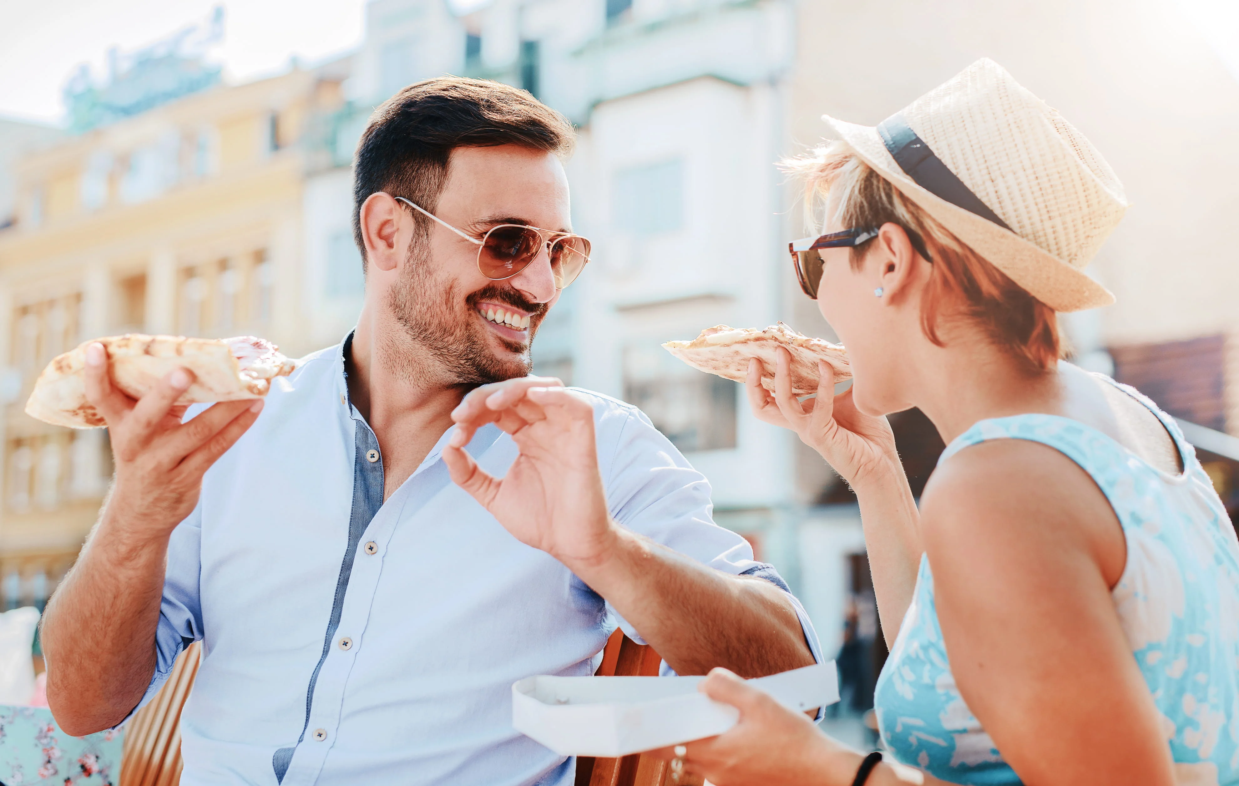 A man and a woman eating lunch outside on a sunny day