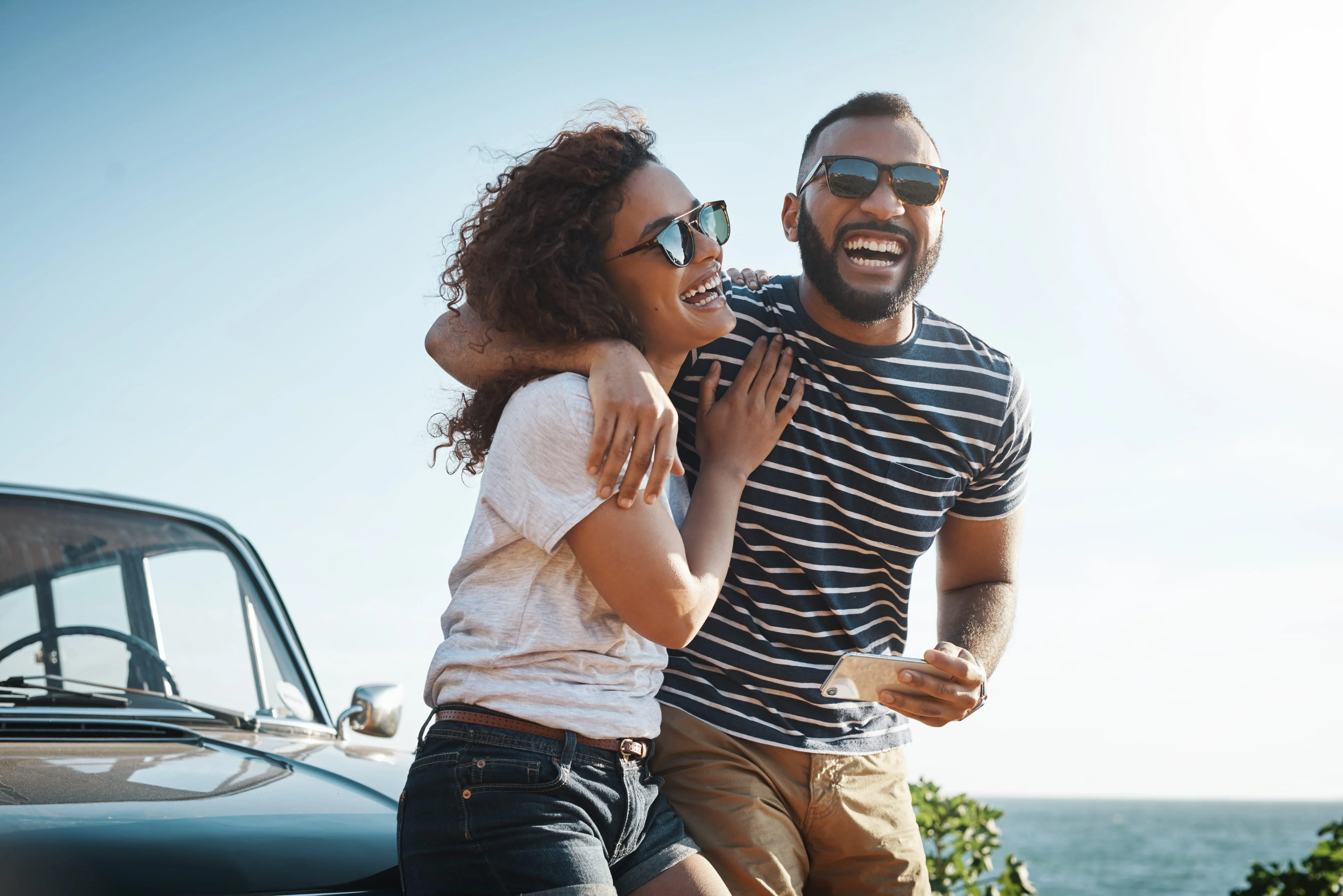 Laughing couple embracing near the coast